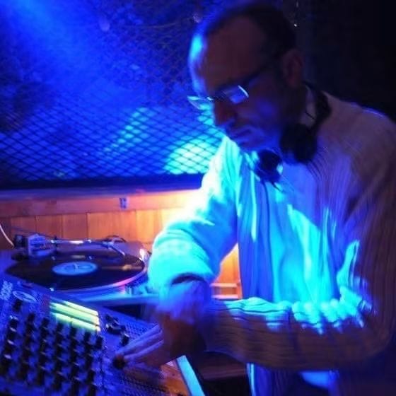 Malik Boudari mixant sous une lumière bleue